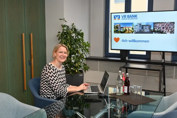 Eine Frau sitzt am Laptop und lacht