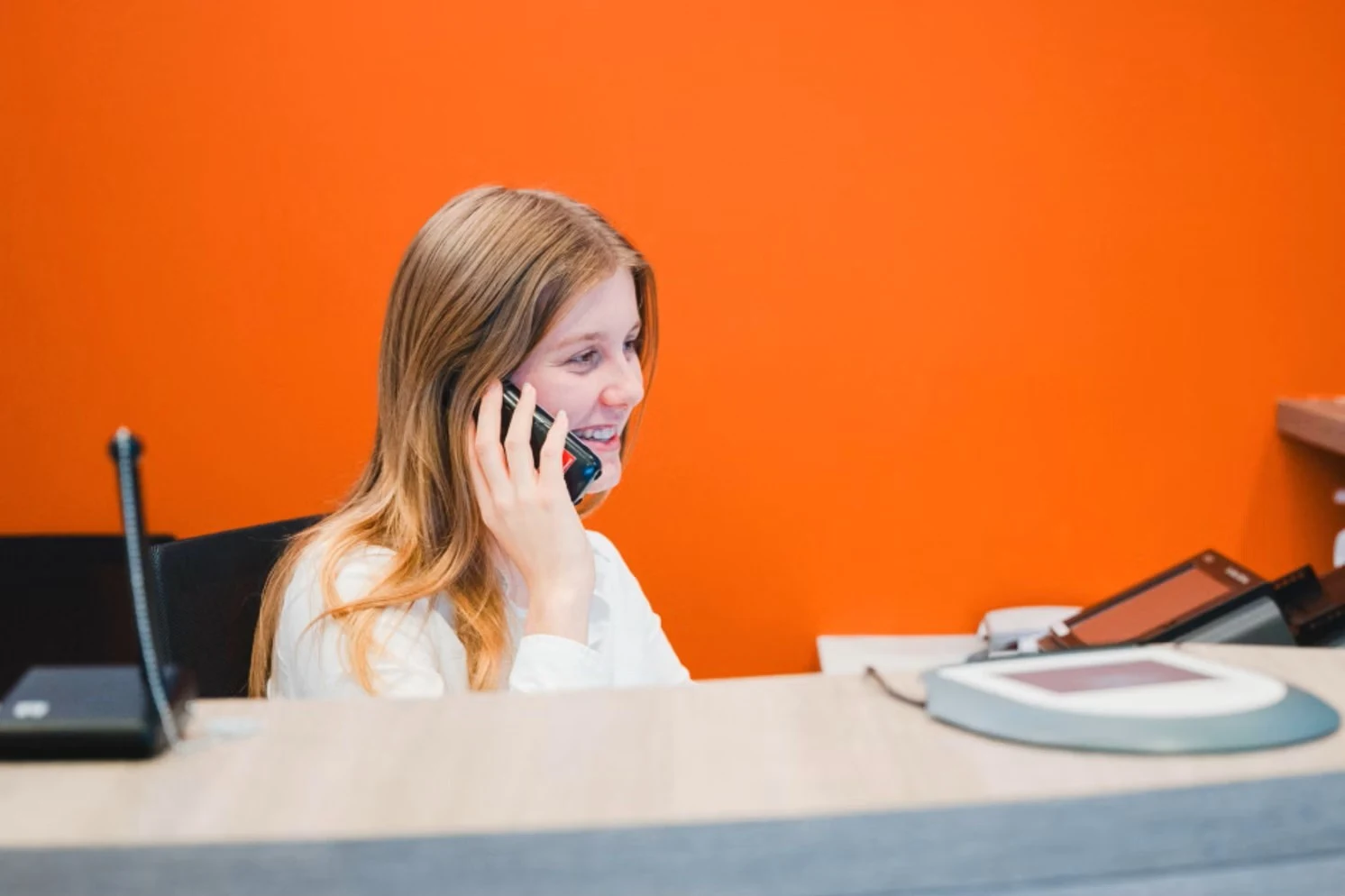 Eine Frau telefoniert am Schalter